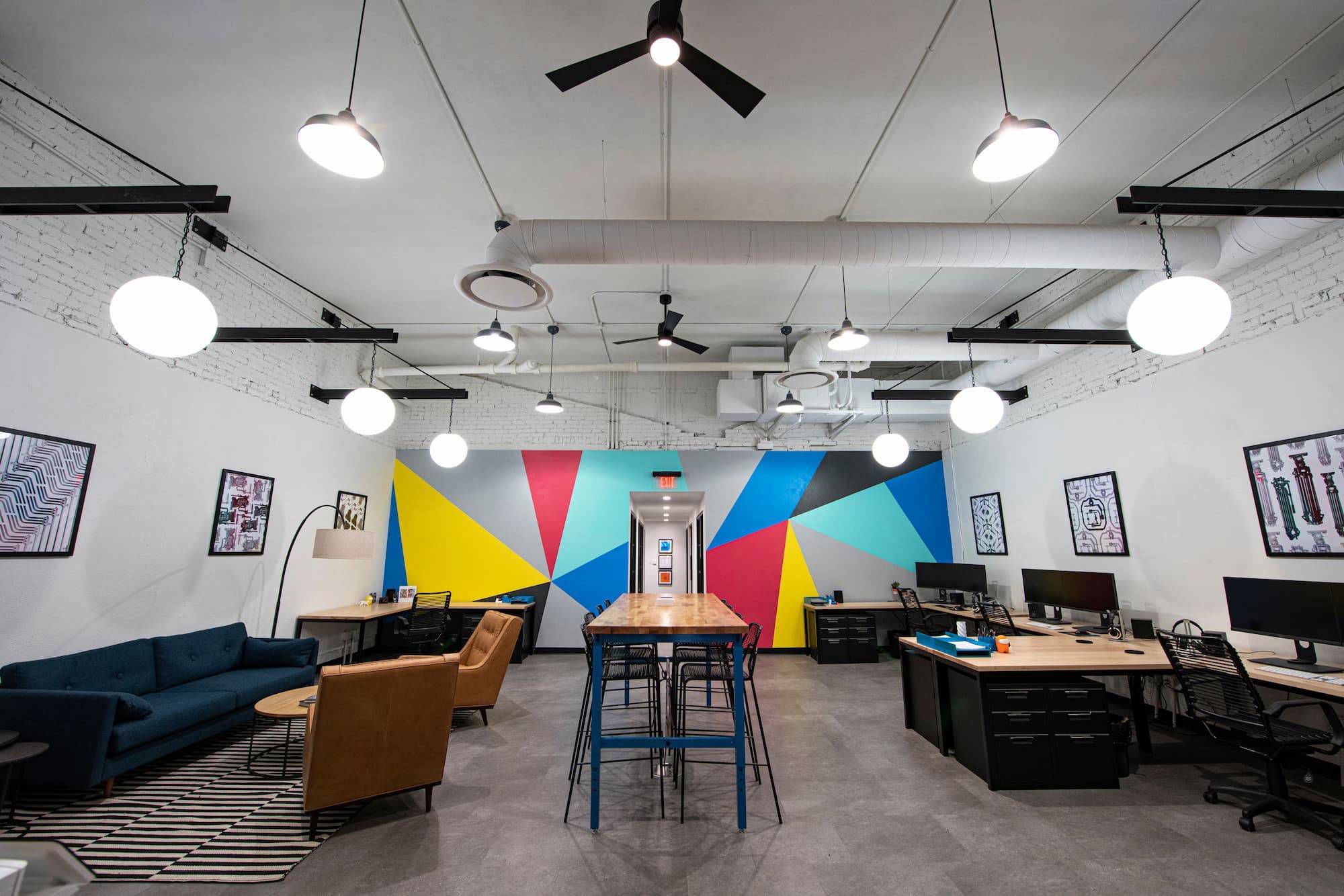 Bullpen style office area with large colorful mural