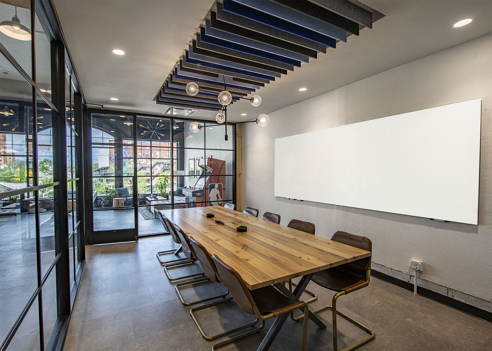 Conference room with glass walls, wood conferences table and clean whiteboard