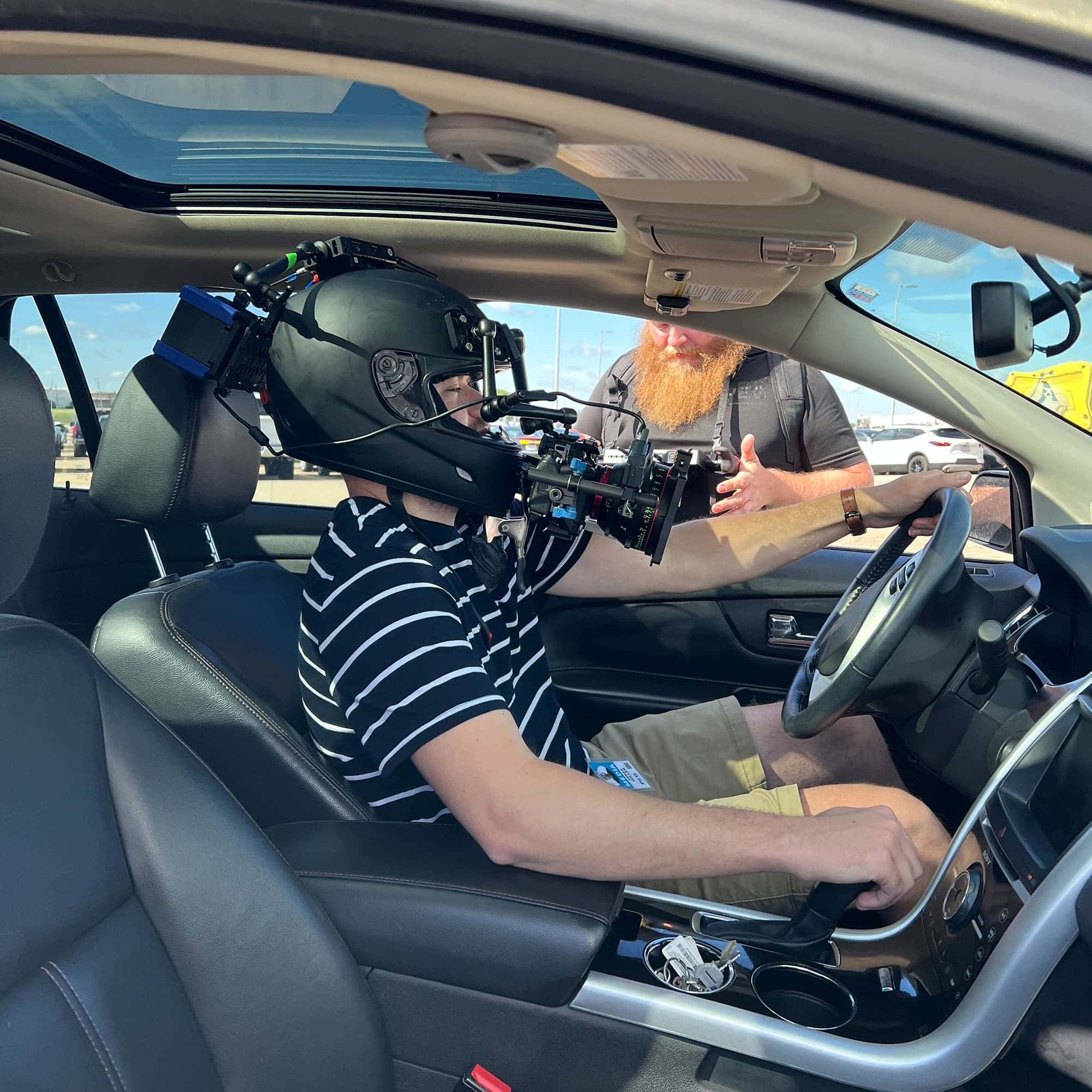 Man wearing helmet camera sitting in drivers seat of a car