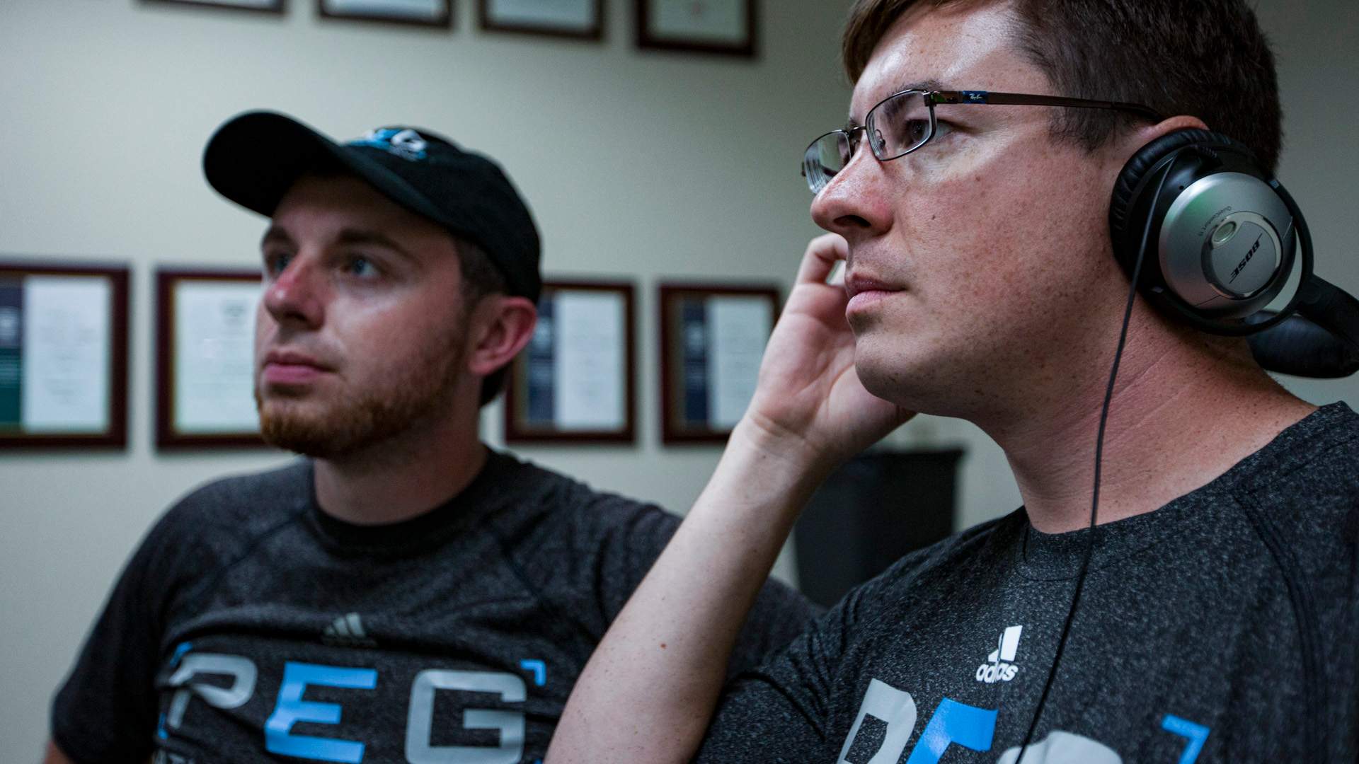 Two men wearing PEG shirts looking to the left of image