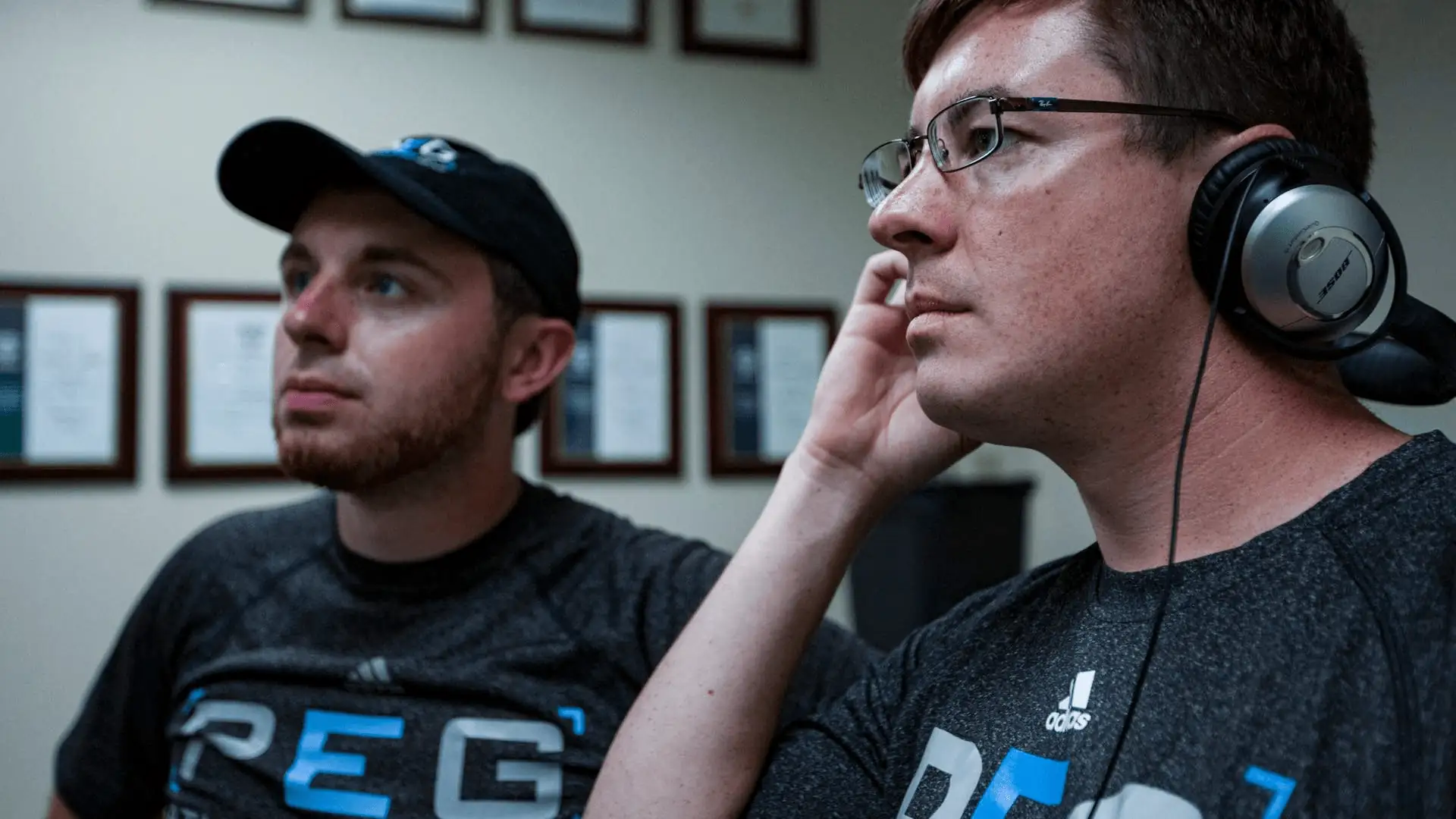 Two men wearing PEG shirts looking to the left of image