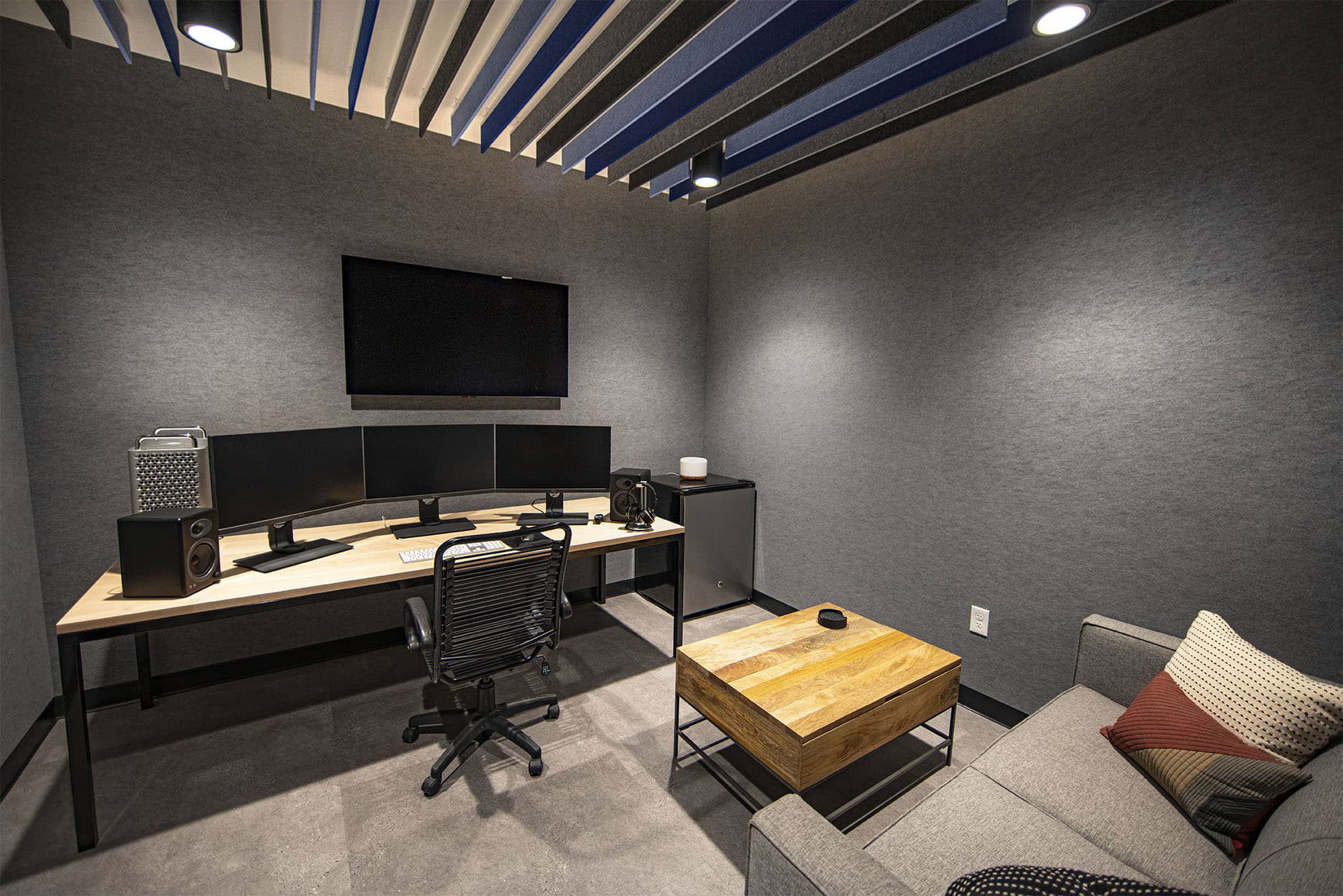 Private editing suite with multiple computer monitors and a couch