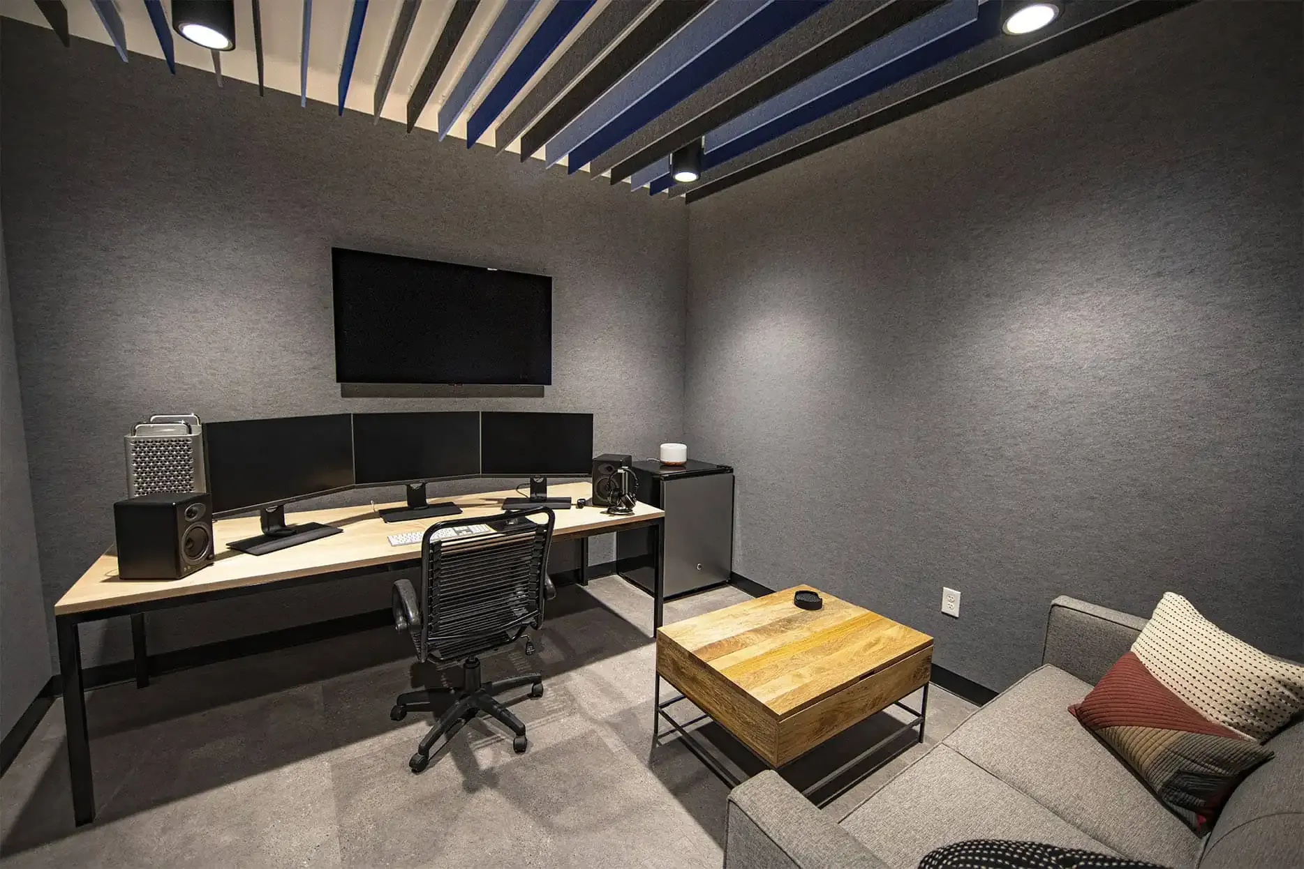 Private editing suite with multiple computer monitors and a couch
