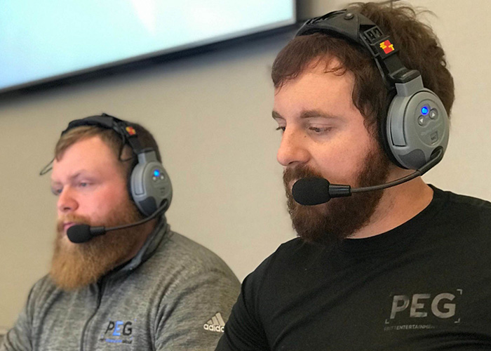 Two men wearing headsets producing a corporate live event